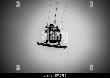 Professionelle Kiter macht den schwierigen Trick auf einem schönen Hintergrund Von Spray und schönen Bergen von Mauritius Stockfoto