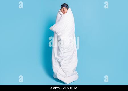 In voller Länge Foto-Porträt von verwirrt verängstigt Mann eingewickelt Decke isoliert auf lebhaft blauem Hintergrund Stockfoto