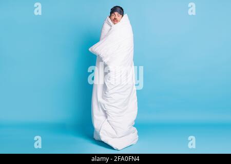 In voller Länge Foto Porträt von erschrockenen Mann in Bettdecke gewickelt Isoliert auf lebhaft blauem Hintergrund Stockfoto