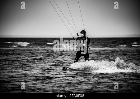 Professionelle Kiter macht den schwierigen Trick auf einem schönen Hintergrund Von Spray und schönen Bergen von Mauritius Stockfoto