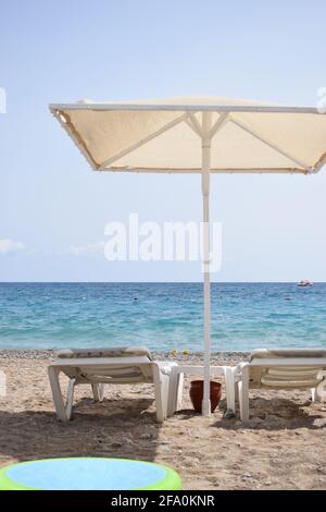 Entspannen am Tropical Beach. Baldachin und Liegestuhl am Strand am Meer. Rettungsring am Sandstrand. Mittelmeer. Stockfoto