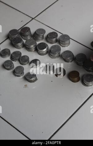 Mann, der indonesischen Penny zählt. Gestapelte Rupiah-Münze. Stockfoto