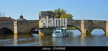 ST IVES, CAMBRIDGESHIRE, ENGLAND - 19. APRIL 1021: Historische Brücke über den Fluss Ouse in St Ives Cambridgeshire mit Flusskreuzfahrtschiff Stockfoto