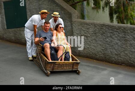 Funchal Madeira Pärchen, die den Korb bergab fahren. Stockfoto