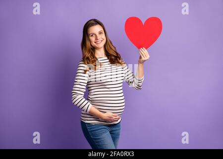 Foto Porträt einer Schwangeren mit großer roter Herzkarte Isoliert auf lebhaft violettem Hintergrund Stockfoto