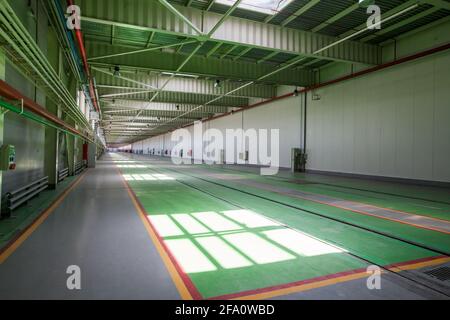 ALocomotive-Building plant. Innenraum der Werkstatt. Helle Sonne mit schönen Schatten. Gleise auf grünem Boden. Stockfoto
