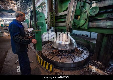 USt'-Kamenogorsk, Kasachstan: Fabrik in Wostokmashzawod. Schwertechnikanlage. Horizontale riesige Drehdrehmaschine.Senior Drehmaschine Operator links. Stockfoto