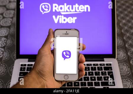 In dieser Abbildung wird eine App von Rakuten Viber auf einem Smartphone-Bildschirm mit einem Rakuten Viber-Logo auf einem Laptop im Hintergrund angezeigt. Stockfoto