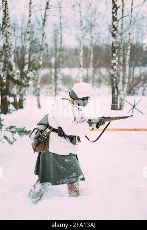 Deutscher Wehrmachts-Infanterie-Soldat im Zweiten Weltkrieg, der im Wintertag mit Gewehr angreift. Historische Reenactment. 2. WELTKRIEG. Stockfoto