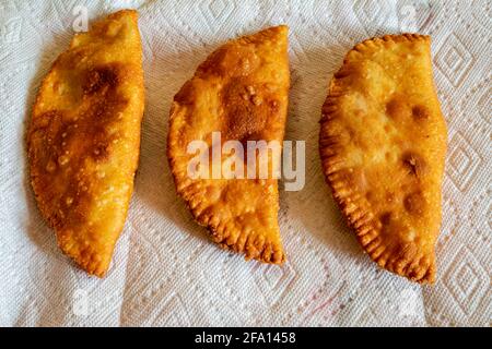 Chebureki ist ein köstliches russisches Straßenessen, das zwischen gebratenem Teig eingeklemmt ist und gewürzte Hackfleischfüllung hat. Stockfoto