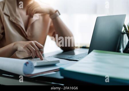 Geschäftsmann, der am Schreibtisch arbeitet, mit einem Rechner, um die Zahlen zu berechnen, Finanzbuchhaltung Konzept. Stockfoto