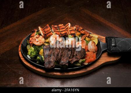 Authentische und traditionelle mexikanische Küche, bekannt als Steak Chicken Shrimps Fajitas Stockfoto