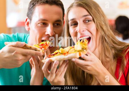 Mann und Frau eine Pizza essen und den Abend genießen Stockfoto