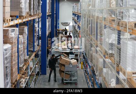 Tornesch, Deutschland. April 2021. Im Logistikzentrum IWL (International Wine Logistics) des Weinhändlers Hawesko verpacken Mitarbeiter bestellte Weine in Kartons. Das Unternehmen versteht sich als Europas größte Weinhandelsgruppe und erzielte 2020 nach vorläufigen Zahlen eine Umsatzsteigerung von zwölf Prozent. Kredit: Marcus Brandt/dpa/Alamy Live Nachrichten Stockfoto