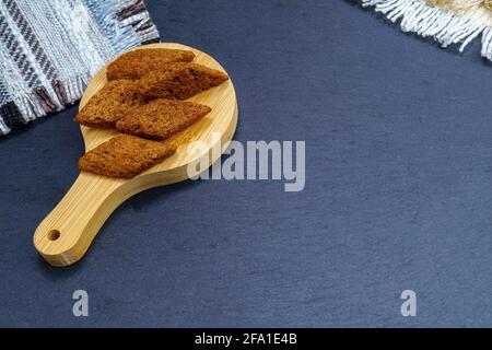 Dunkle Croutons aus der Nähe auf einem Holzbrett. Nahaufnahme. Selektiver Fokus. Stockfoto