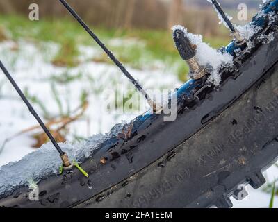 Presta Ventilschaft des Innenrohrs des MTB-Rades. Schneebedeckter und eisiger Rand des Mountainbikes nach der Fahrt in der sn Owy Landschaft. Stockfoto