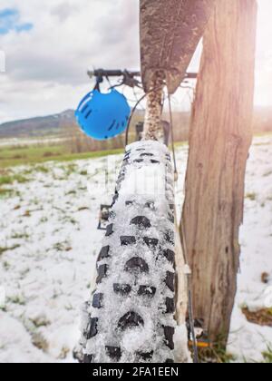 Beobachten Sie Fahrrad Vorderrad im Schnee. Detailreiche Nahaufnahme aus tiefem Winkel. Verschneit in offener Landschaft. Stockfoto