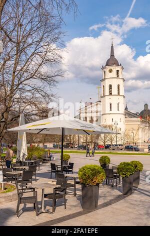 Vilnius hat Bars und Restaurants nach der Sperre wegen Covid oder Coronavirus wieder geöffnet, Tische, Stühle und Sonnenschirme mit dem Turm der Kathedrale im Hintergrund Stockfoto