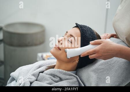 Der Kunde des Schönheitssalons wird einem Gesichtsliftungsverfahren unterzogen Stockfoto