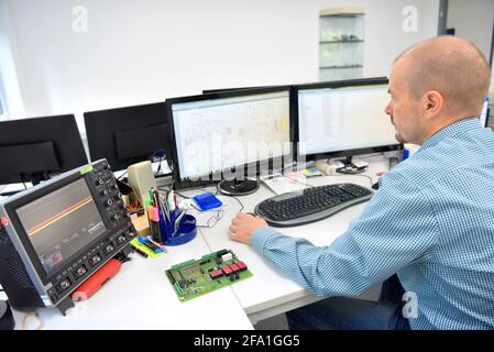 Ingenieur am Arbeitsplatz - Montage und Entwicklung von Elektronik in ein modernes Werk Stockfoto