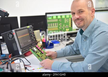 Ingenieur am Arbeitsplatz - Montage und Entwicklung von Elektronik in ein modernes Werk Stockfoto