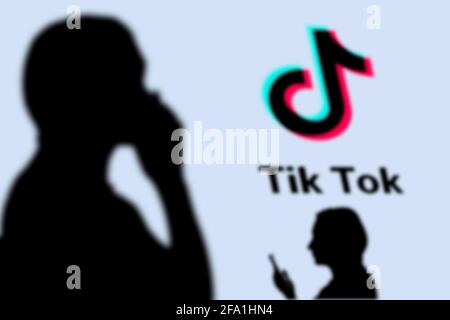 Taschkent, Usbekistan - 4. März 2021: Silhouette der Menschen über beliebte Social-Media-Plattform - TikTok-Logo auf einem großen Bildschirm Stockfoto