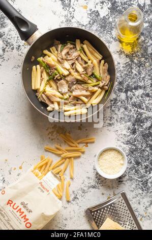 Pfanne voll mit italienischer Pasta, genannt "caserecce" mit Pilzen (pleurotus) und Spargel Stockfoto