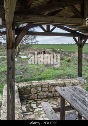 Mittelalterliche Brücke von Santiago de Bencaliz in der Nähe des Dorfes Aldea del Cano, Caceres, Spanien. Überdachter Picknickbereich Stockfoto