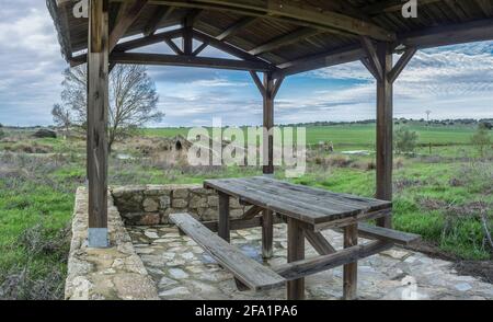 Mittelalterliche Brücke von Santiago de Bencaliz in der Nähe des Dorfes Aldea del Cano, Caceres, Spanien. Überdachter Picknickbereich Stockfoto