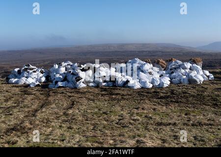 Säcke mit geerntetem Heidekraut, die auf restaurierten Torfböden verstreut werden, um Heidekraut wiederherzustellen. North Yorkshire, Großbritannien. Stockfoto