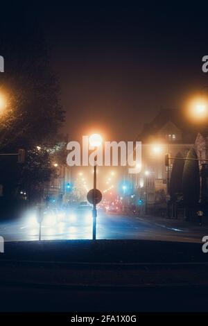 Avenue (Straße) während einer regnerischen Nacht in München, Bayern, Deutschland. Verkehrszeichen und Kreisverkehr. Scheinwerfer und Stau beleuchten die Stadt. Stockfoto