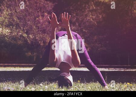 Frau im Park in Kopfstand-Position Stockfoto