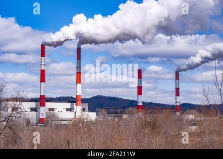 Dichter Rauch kommt aus den Rohren einer kleinen Fabrik.Durchschnittliche atmosphärische Emissionen. Stockfoto