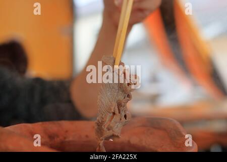 Hand mit Essstäbchen mit Rindfleisch Stockfoto