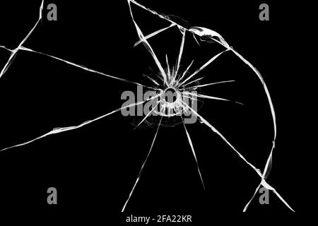 Die Wirkung der Risse auf das zerbrochene Glas aus dem Schuss der Waffe. Ein Loch im Glas der Kugel Stockfoto