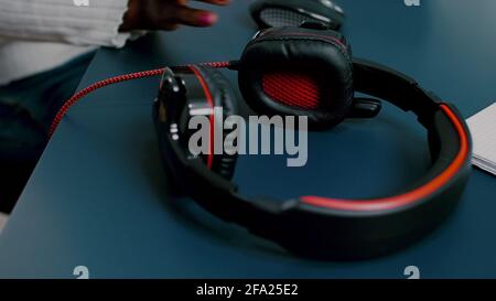 Schwarzer Videoeditor, der mit Filmmaterial auf dem pc mit zwei Monitoren arbeitet und Kopfhörer aufsetzt. Afrikanischer Videofilmer, der mit Post-Production-Software Filme bearbeitet, die in einem Büro der Kreativagentur arbeitet. Stockfoto