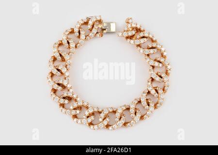 Goldenes Armband mit Diamanten auf grauem Hintergrund. Luxuriöses Armband aus Gelbgold mit Diamant-Schmuck Stockfoto