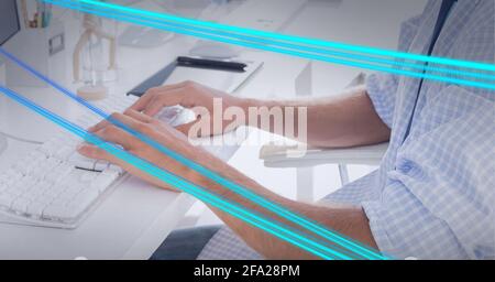 Zusammensetzung von blauen Lichtspuren über den Menschen mit Computer in Büro Stockfoto