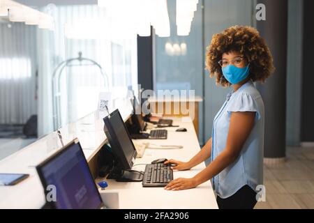 Porträt einer Frau mit Gesichtsmaske, die als Empfangsdame arbeitet Hotel Stockfoto