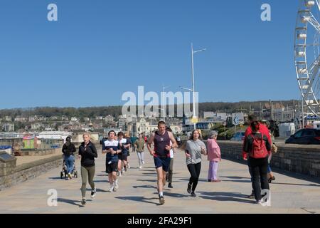 Weston-super-Mare, Somerset, Großbritannien. April 2021. Der blaue Himmel hat einige sehr begeisterte Jogger nach draußen gebracht, um die Meeresluft zu genießen. Kredit: JMF Nachrichten/Alamy Live Nachrichten Stockfoto