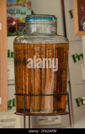 apfelsaft in Glasflasche, Displaymaterial mit Behälterboxen im Hintergrund Stockfoto