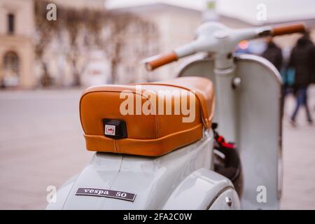 Blauer Klassiker vespa 50 mit braunem Ledersitz in der Stadt München, Bayern, Deutschland. Der Roller ist bekannt für Freiheit, Urlaub, Nostalgie. Stockfoto