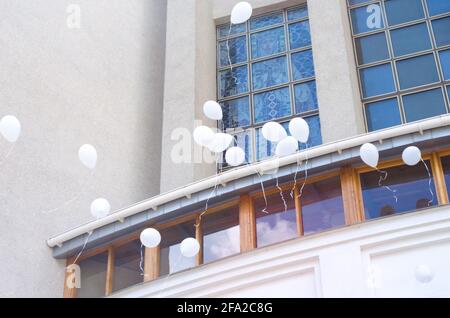 Weiße Kugeln auf dem Hintergrund der Kirchenfenster Foto. Konzept der ersten Kommunion. Stockfoto