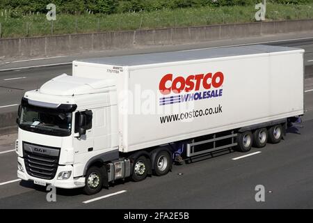 Vorderansicht der Seite, weißer Lieferkettenladen, Lieferwagen & Costco Großhandel Anhänger Werbung Unternehmen Markennamen & Logo Fahren Sie auf der britischen Autobahn Stockfoto