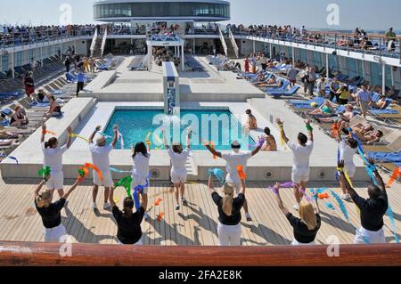 Blick auf das Sonnendeck des Swimmingpools auf dem Kreuzfahrtschiff Costa Classica Schiffe Entertainment-Team Förderung der Bewegung durch die aktive zu halten Abfahrt in Dubai, VAE Stockfoto