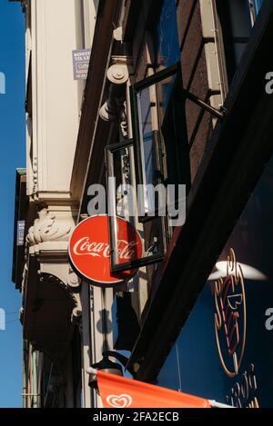 Kopenhagen, Dänemark - 14. September 2020. Rundes rotes Plakat mit dem Logo der Firma Coca Cola auf einem der Häuser auf der Straße in Kopenhagen Stockfoto