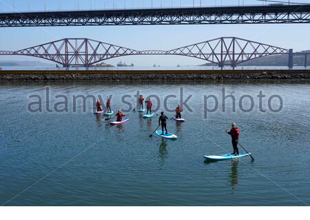 South Queensferry, Schottland, Großbritannien. April 2021. Klar und sonnig an der South Queensferry und der Port Edgar Marina. Menschen, die das Beste aus dem guten Wetter machen und beginnen, die Natur an den üblichen Besucher-Hotspots zu besuchen und zu genießen. Paddelbordunterricht in Port Edgar Marina. Kredit: Craig Brown/Alamy Live Nachrichten Stockfoto