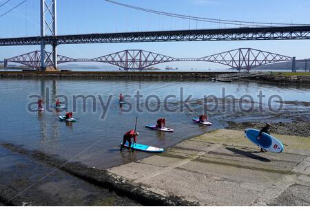 South Queensferry, Schottland, Großbritannien. April 2021. Klar und sonnig an der South Queensferry und der Port Edgar Marina. Menschen, die das Beste aus dem guten Wetter machen und beginnen, die Natur an den üblichen Besucher-Hotspots zu besuchen und zu genießen. Paddelbordunterricht in Port Edgar Marina. Kredit: Craig Brown/Alamy Live Nachrichten Stockfoto