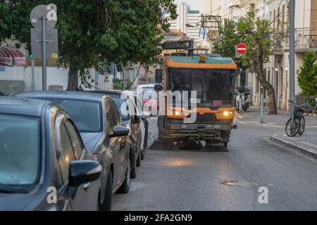 Tel Aviv, Israel - 17. April 2021: Eine mechanische Straßenkehrmaschine, die die Straßen von Tel Aviv, Israel, im Morgengrauen reinigt. Stockfoto