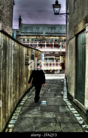 Mann mit flacher Mütze, der in der Gasse läuft Stockfoto